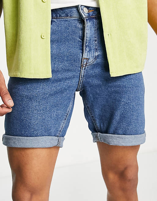 ASOS DESIGN stretch mid length denim shorts in flat mid wash blue