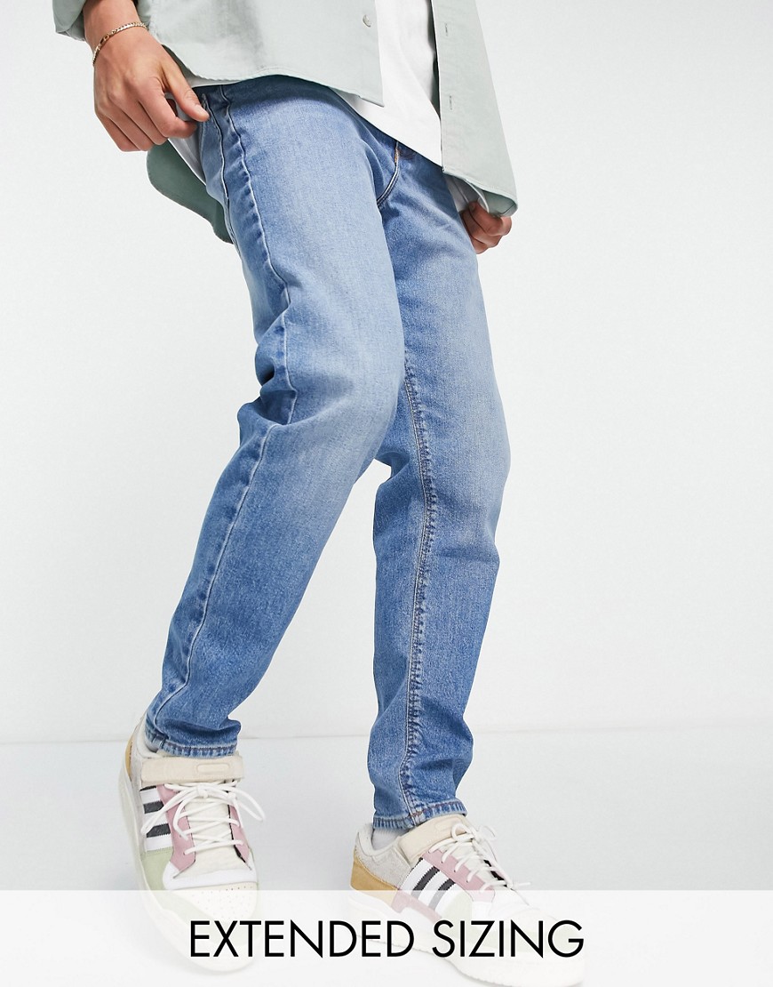 ASOS DESIGN stretch tapered jeans in 90s mid wash-Blue