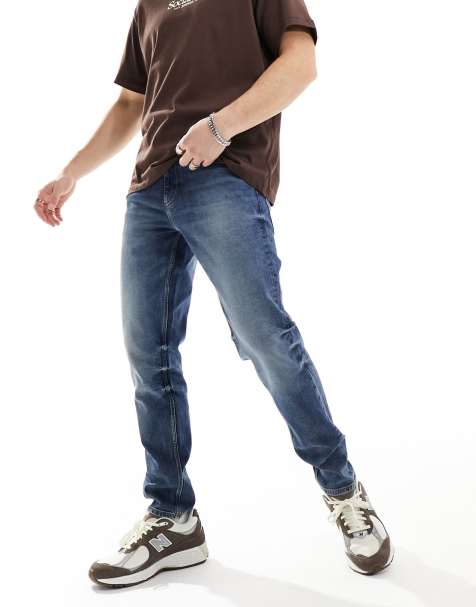 ASOS DESIGN stretch tapered jeans in dark wash blue - view 1