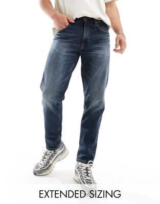 stretch tapered jeans in dark wash blue