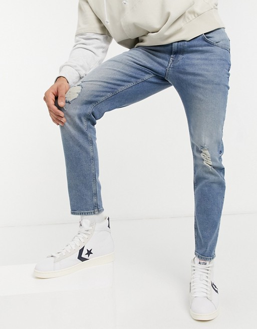 ASOS DESIGN stretch tapered jeans in mid wash with knee rips