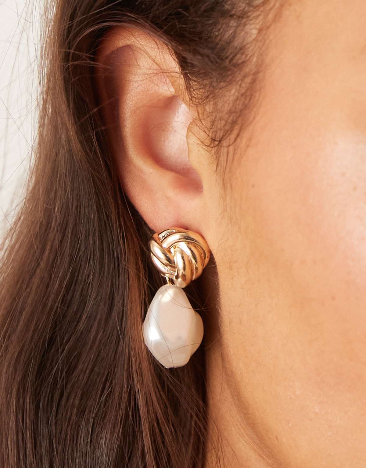 ASOS DESIGN stud earrings with knot detail and faux freshwater pearl drop in gold tone