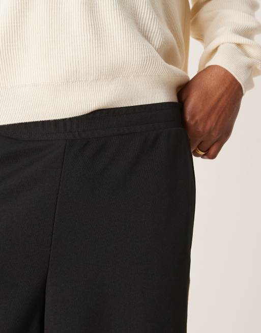 ASOS DESIGN super baggy trackies with taping in black