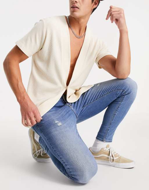 ASOS DESIGN - Superstrakke jeans met krachtige stretch en slijtageplekken in middenblauwe wassing