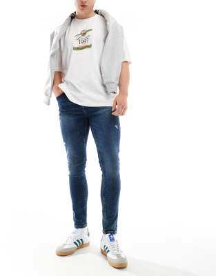 ASOS DESIGN - Superstrakke jeans met powerstretch en slijtageplekken in donkere wassing blauw