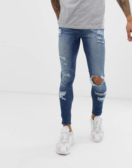 ASOS DESIGN - Superstrakke jeans van stevig stretchdenim met grote scheuren in mediumblauwe wassing