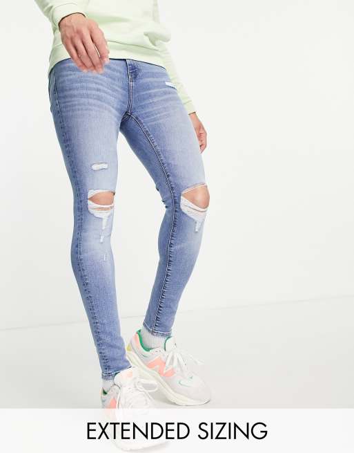 ASOS DESIGN - Superstrakke spray-on jeans met powerstretch, kniescheuren en slijtages in blauw met medium wassing