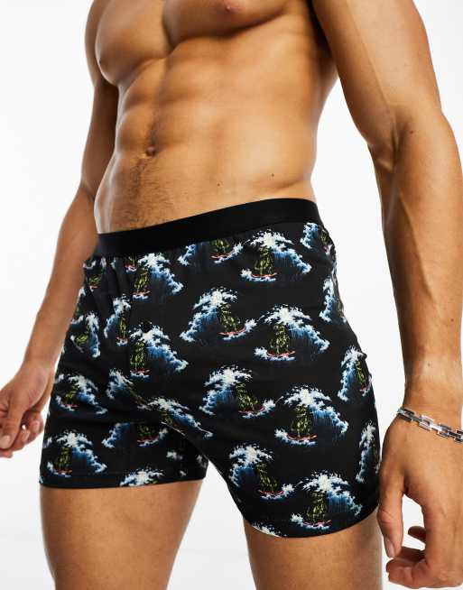 ASOS DESIGN surfing dinosaur print boxers in black