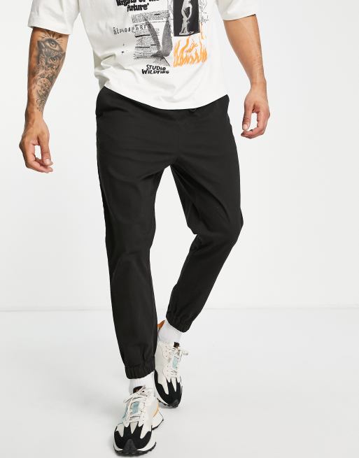 ASOS DESIGN – Svarta avsmalnande mjukisbyxor i chinos-modell med elastisk midja