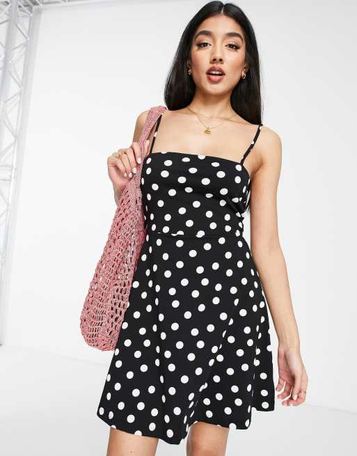 ASOS DESIGN – Svartvit prickig solklänning i kort längd med smala axelband och knyt baktill