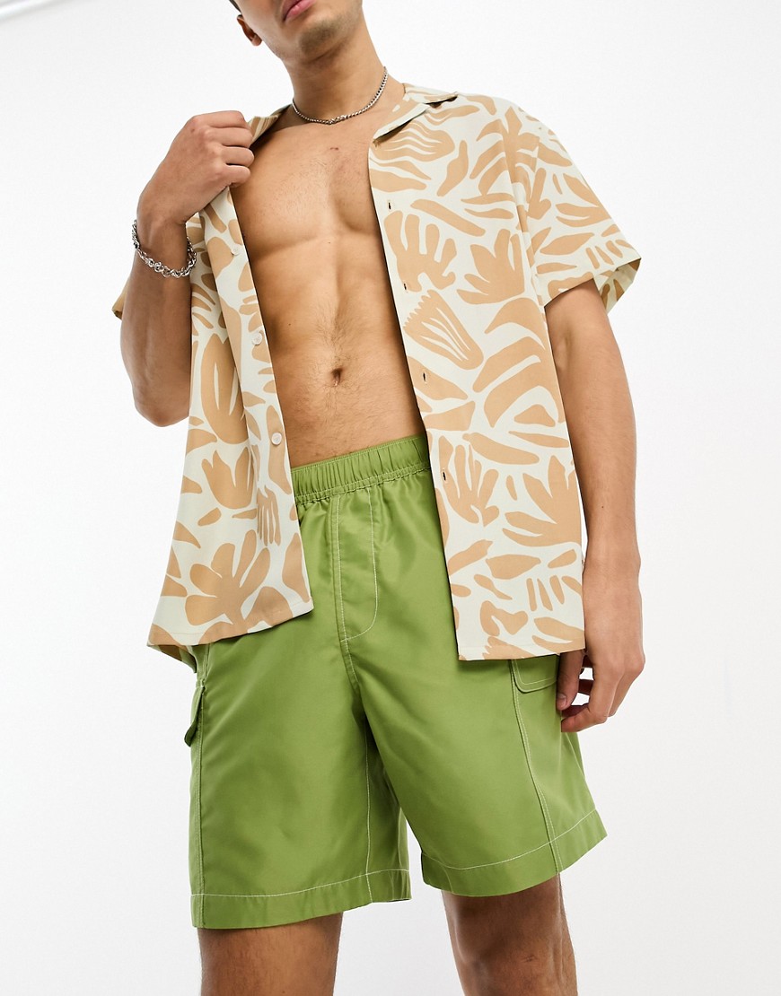 ASOS DESIGN swim shorts in mid length with cargo pockets in green