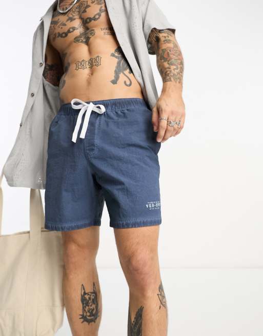 ASOS DESIGN swim shorts in mid length with placement print in navy