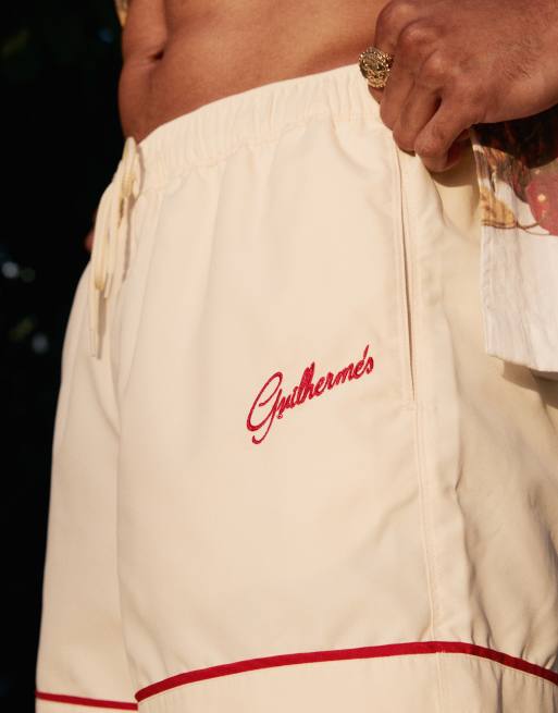 ASOS DESIGN swim shorts in short length in neutral with placement embroidery
