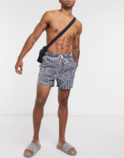 ASOS DESIGN swim shorts in short length with abstract print in navy acid wash