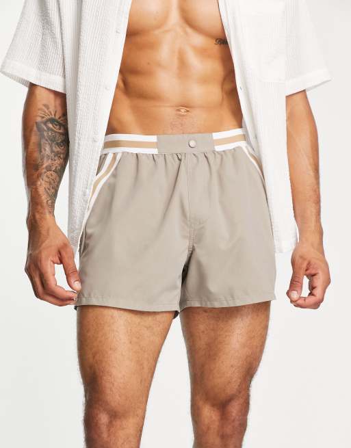 ASOS DESIGN swim shorts in short length with contrast waistband and tape detailing in beige