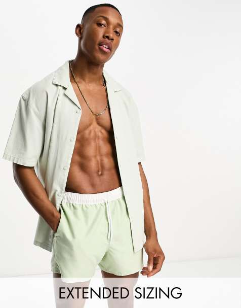 ASOS DESIGN swim shorts in short length with contrast waistband in light green - view 1