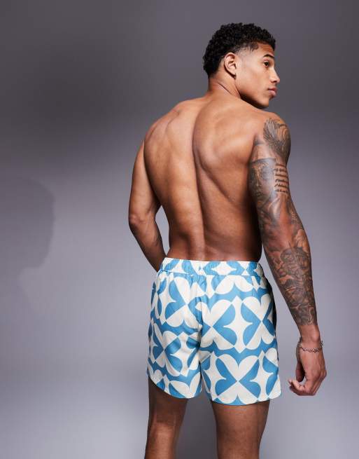 ASOS DESIGN swim shorts in short length with geo print in blue