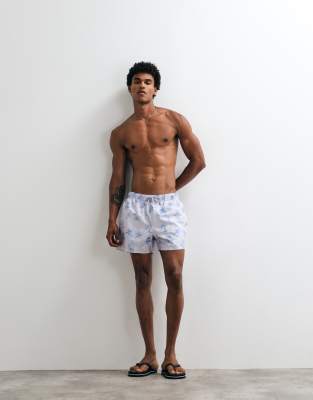 ASOS DESIGN swim shorts in short length with palm tree print in washed blue
