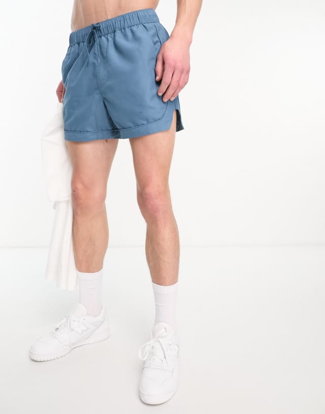 ASOS DESIGN swim shorts in short length with piping detail in turquoise