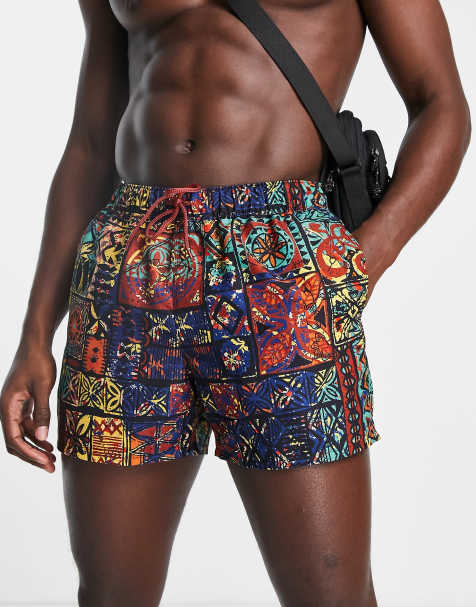 ASOS DESIGN swim shorts in short length with retro tapestry print in orange - view 1