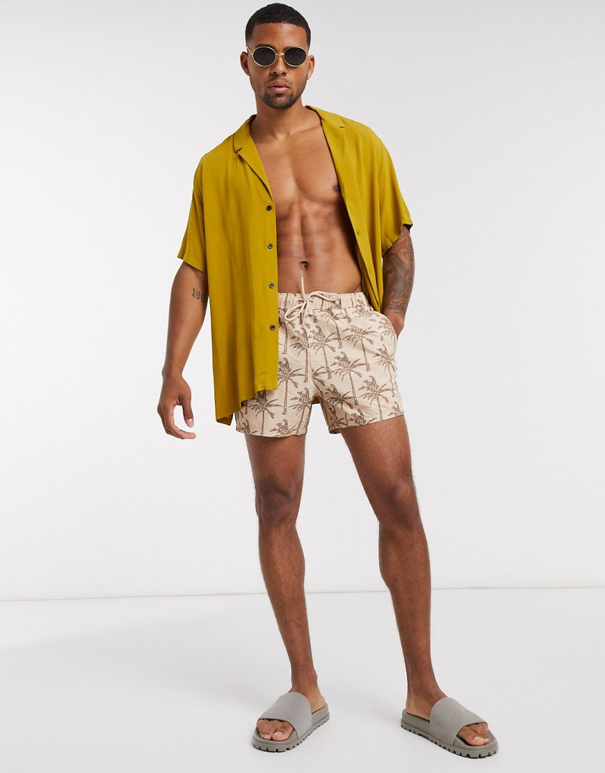 ASOS DESIGN swim shorts in stone seersucker with tonal palm print-Beige