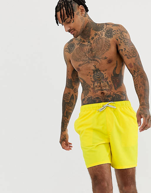 ASOS DESIGN swim shorts in yellow in mid length