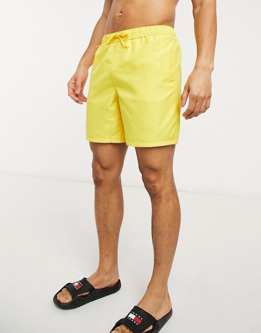 ASOS DESIGN swim shorts in yellow mid length