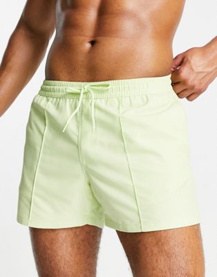 ASOS DESIGN swim shorts with curved hem in lime green short length