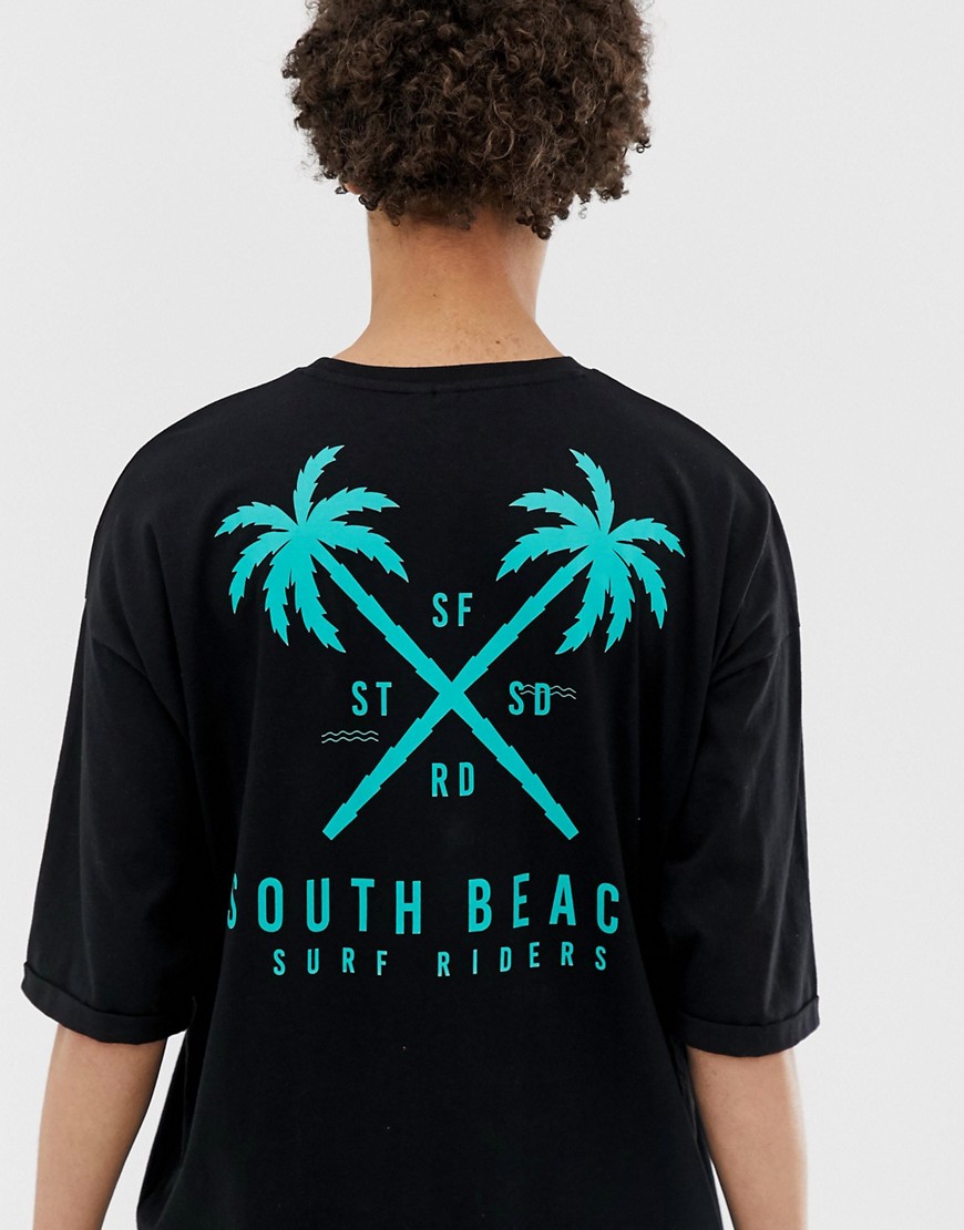 ASOS DESIGN - T-shirt lunga oversize in cotone biologico con stampa di palma sul davanti e sul retro a mezze maniche con risvolto-Nero