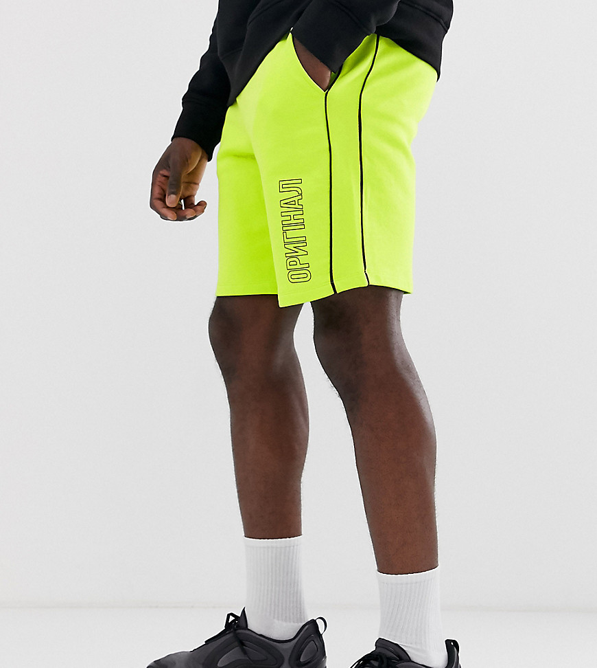 ASOS DESIGN Tall jersey shorts in washed neon with text print-Yellow