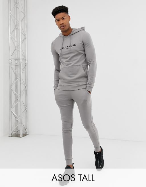 ASOS DESIGN Tall - Trainingspak met aansluitende hoodie en skinny joggingbroek met tekst ville amour in grijs