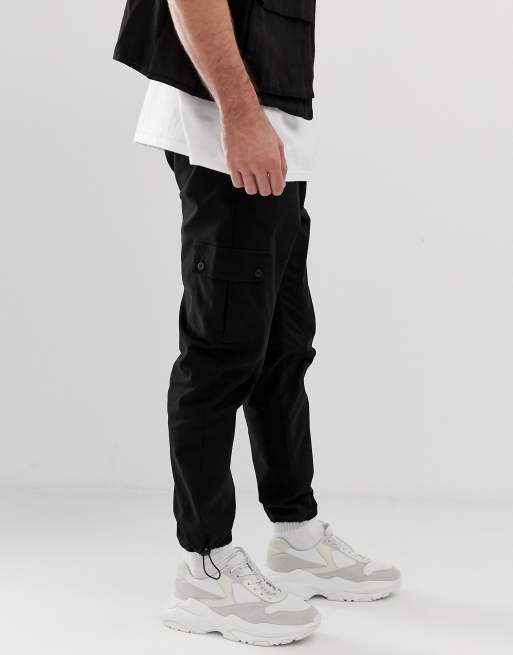 ASOS DESIGN tapered cargo pants in black with toggles