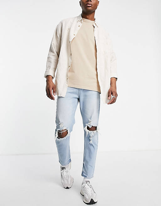 ASOS DESIGN tapered carrot jeans in light wash blue with knee rips
