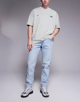 ASOS DESIGN tapered fit jeans in light wash blue