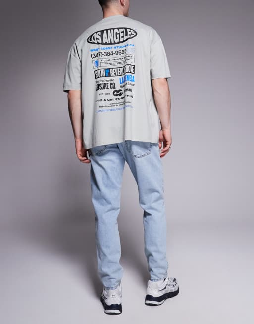ASOS DESIGN tapered fit jeans in light wash blue, 2 of 5