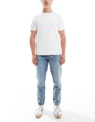 ASOS DESIGN tapered fit jeans in mid wash blue