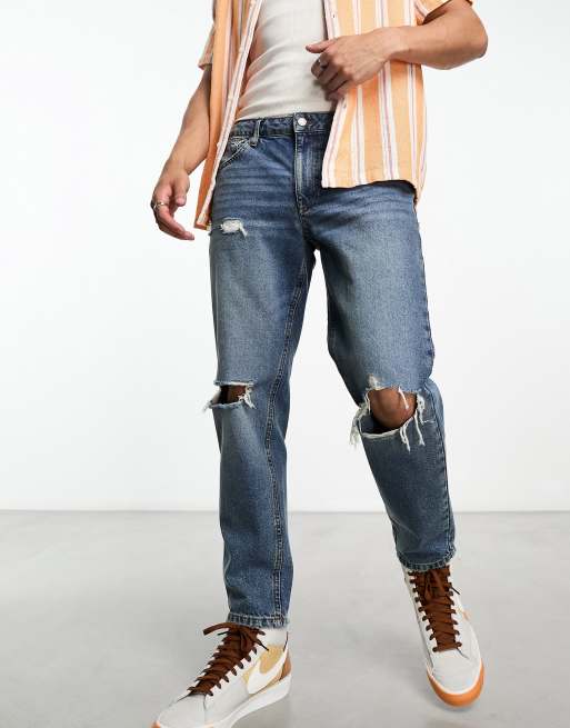 ASOS DESIGN tapered fit jeans with heavy knee rips in mid wash blue  - MBLUE