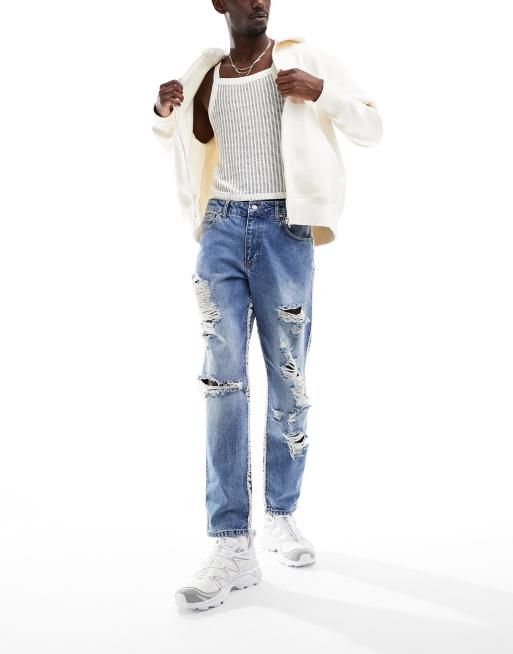 ASOS DESIGN tapered fit jeans with heavy rips in mid wash blue 