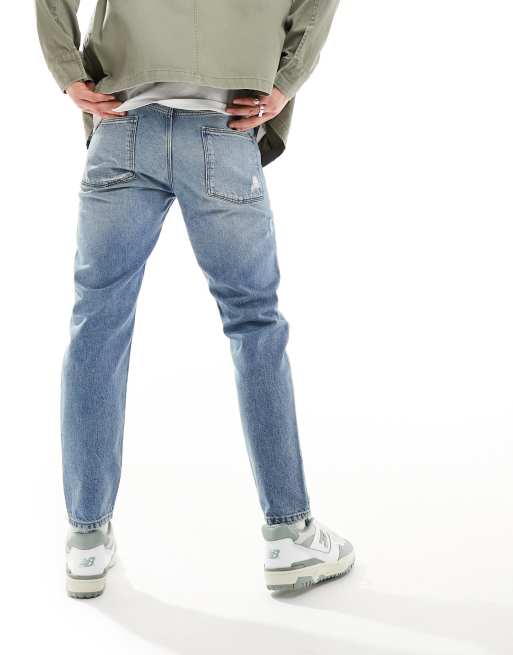 ASOS DESIGN tapered fit jeans with rips in light wash blue , 3 of 5
