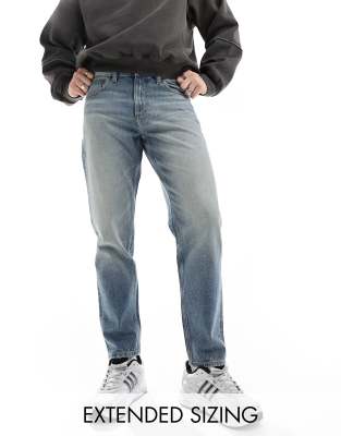 tapered fit jeans with vintage tint in mid wash blue