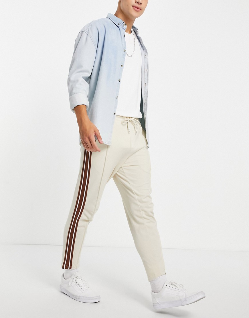 ASOS DESIGN tapered fixed hem sweatpants with pin tucks & side tape in beige-Neutral