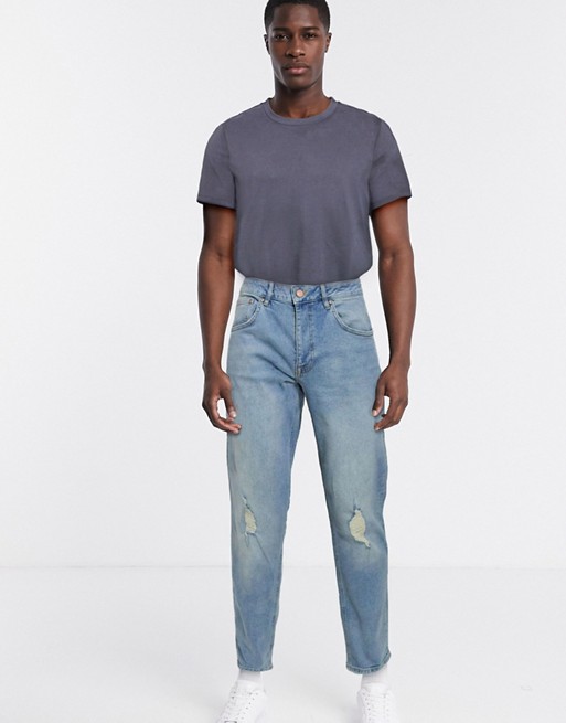 ASOS DESIGN tapered jeans in light wash blue with knee rips