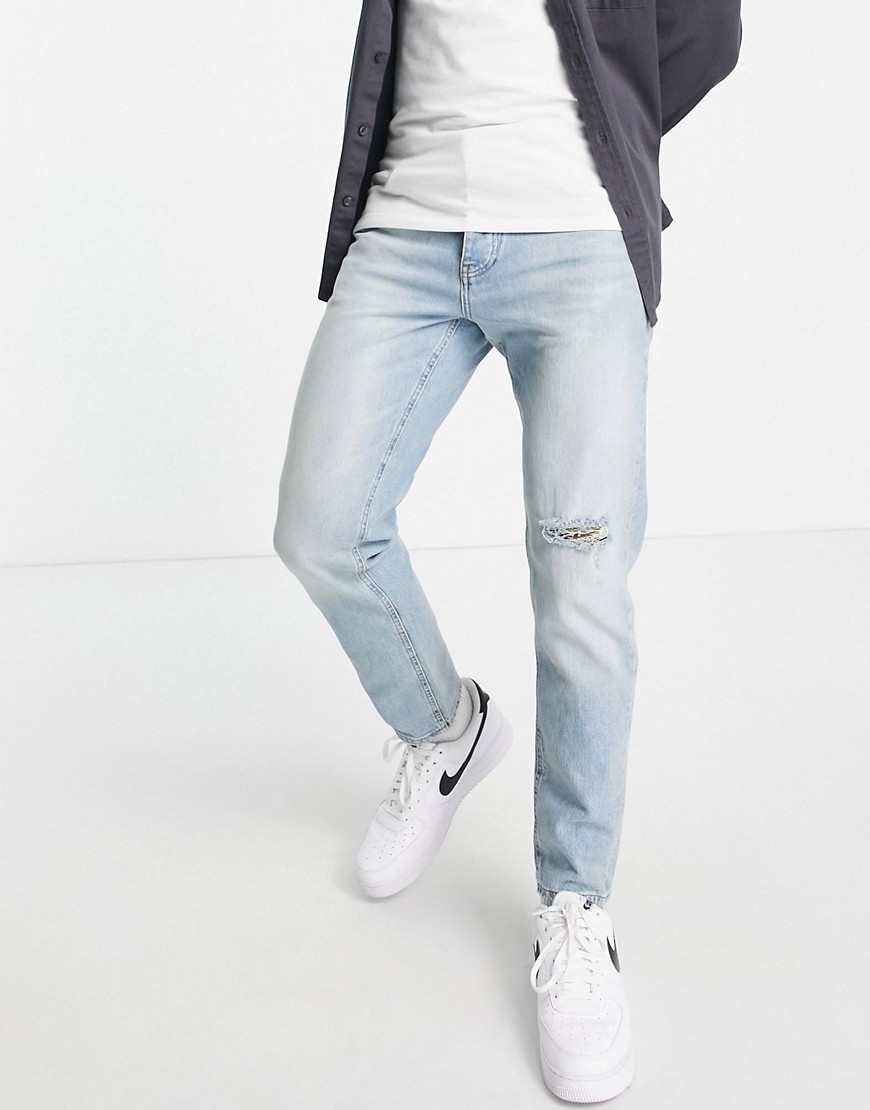 ASOS DESIGN tapered jeans in vintage light wash with rip-Blues