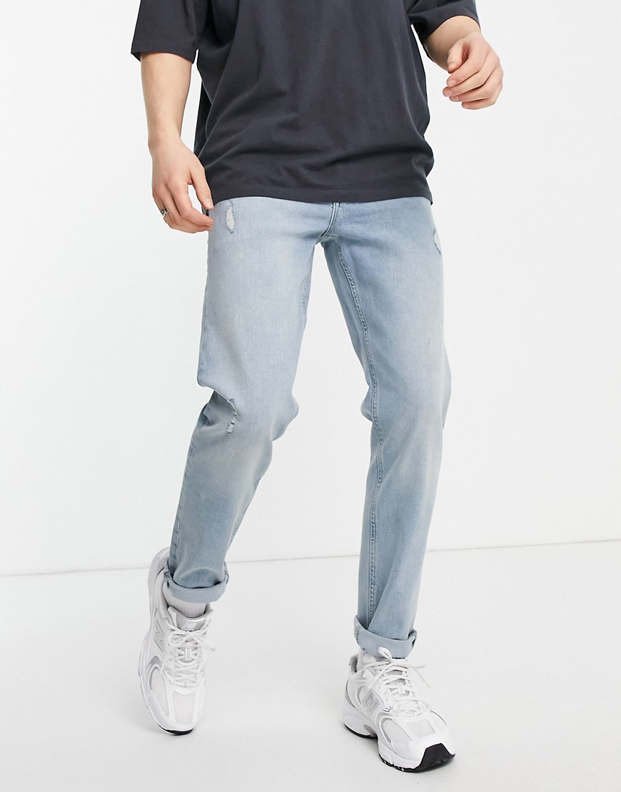 ASOS DESIGN tapered jeans in vintage mid wash with abrasions-Blues