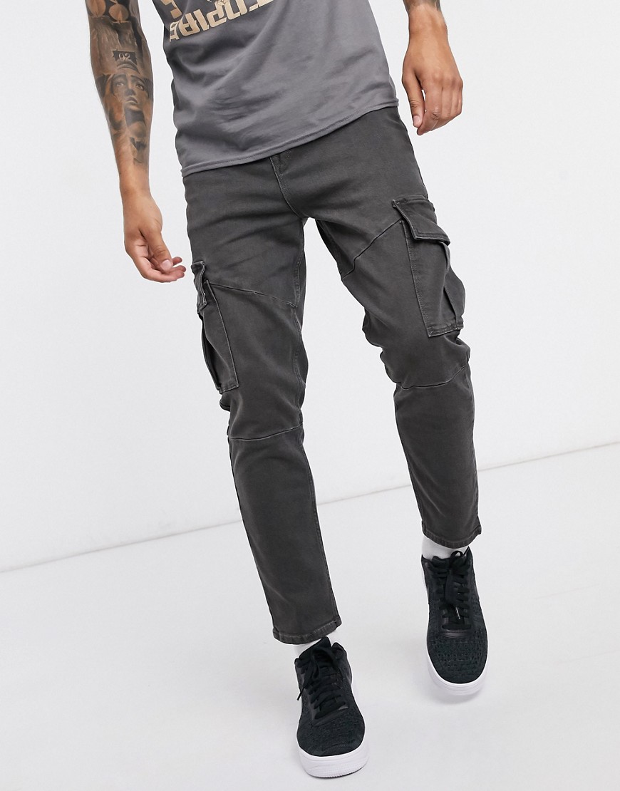 ASOS DESIGN tapered jeans in washed black with cargo pockets and seam details