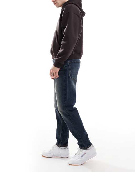 ASOS DESIGN tapered jeans with vintage tint in dark wash blue
