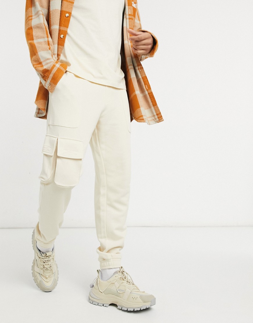 ASOS DESIGN tapered joggers with multi utility pockets & velcro tab cuffs in off-white-Neutral