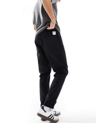 tapered pull on pants in black with patch