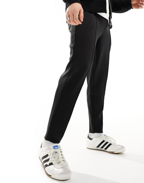 ASOS DESIGN baggy nylon track pants in navy with white piping