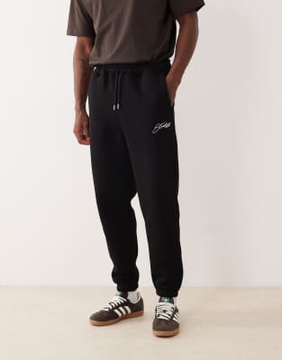 ASOS DESIGN tapered trackies with embroidery print in black | ASOS